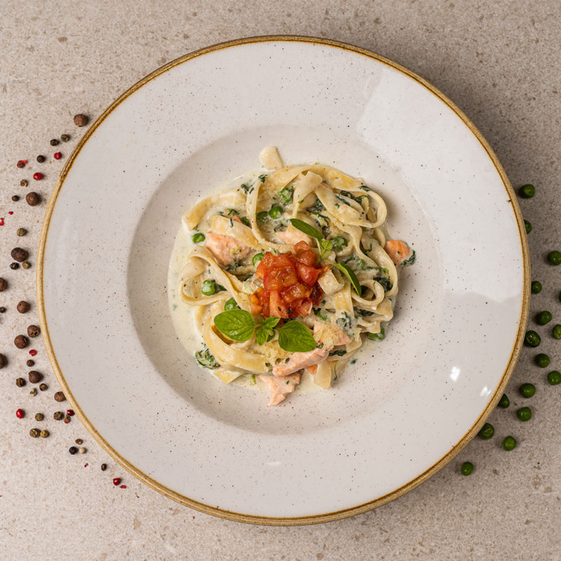 Тальятеле з лососем, шпинатом та зеленим горошком під вершковим соусом